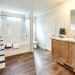 Skyline Homes Arlington G561 Manufactured Home Master bathroom featuring single vanity, shower bath, toilet, walk-in closet