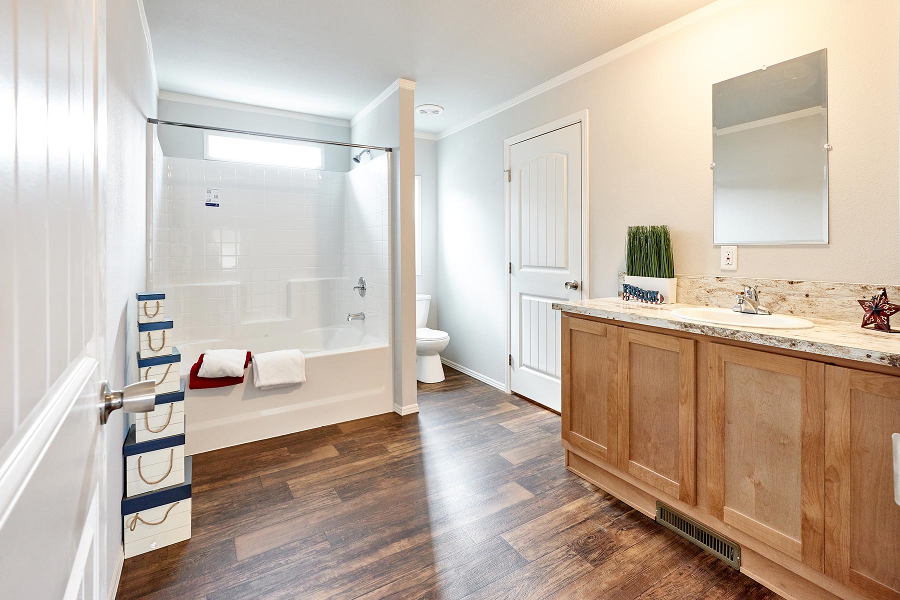Skyline Homes Arlington G561 Manufactured Home Master bathroom featuring single vanity, shower bath, toilet, walk-in closet