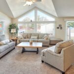 Skyline Homes Westridge 1218CT Manufactured Home Living Room featuring large windows, carpet flooring, and vaulted ceiling