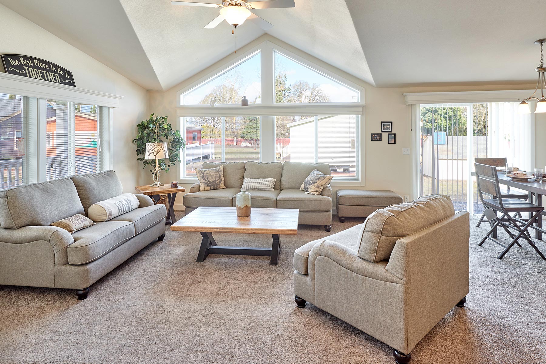 Skyline Homes Westridge 1218CT Manufactured Home Living Room featuring large windows, carpet flooring, and vaulted ceiling