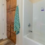 Skyline Homes Westridge 1473CT Manufactured Home Second bathroom featuring single vanity, shower bath, linen cabinet, toilet