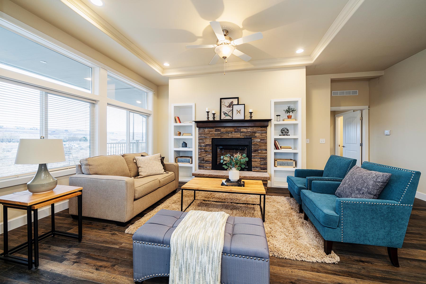 Skyline Homes Westridge 1492CT Manufactured Home Living room featuring fireplace, built-in shelving, large windows, ceiling fan
