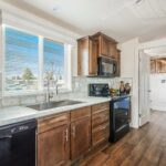 Skyline Homes Westridge 1227CT Manufactured Home Kitchen featuring island, appliances, small window, pantry