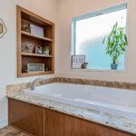 Skyline Homes Woodbridge 7526 Manufactured Home Master bathroom featuring double vanity, platform bathtub, shower, linen cabinet, toilet