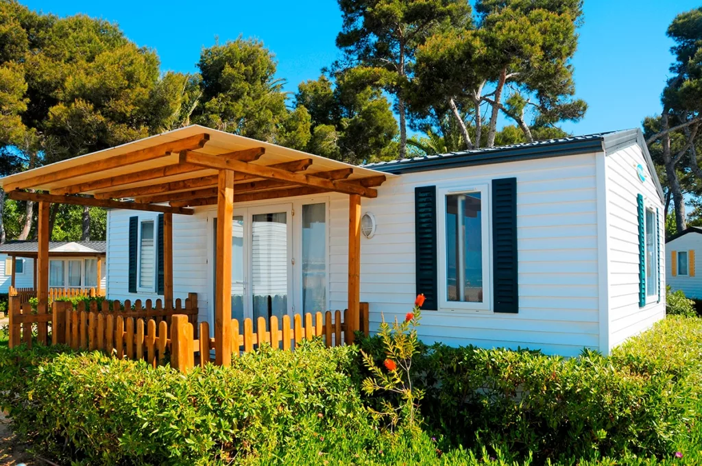 A beautiful modern manufactured home painted white with blue accents and an exterior patio located in Oregon
