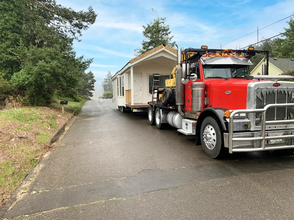 A manufactured home being transported by an semi truck for delivery and installation 