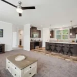 spacious living room across for an open-concept kitchen with kitchen island, bar seating, and granite counters