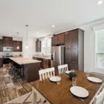 open kitchen concept with kitchen island and bar seating, granite counters, dark wood cabinets, nickel hardware, and stainless steel appliances