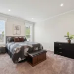 spacious primary bedroom with chocolate brown carpeting, walk-in closet, recessed lighting, and windows on either side of the bed