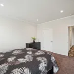 spacious primary bedroom with chocolate brown carpeting, walk-in closet, and recessed lighting