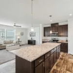 granite kitchen island with bar seating across from a living living room