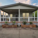 covered wraparound porch with iron railing, recessed lighting, and short stairway