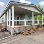 covered wraparound porch with iron railing, recessed lighting, and short stairway