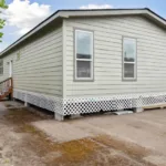 backdoor entrance with lattice skirting around the bottom of the home foundation