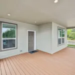 covered wraparound porch with iron railing and short stairway