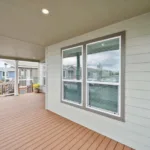 covered wraparound porch with iron railing and short stairway