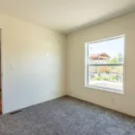 room with dark grey carpeting and large window