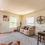 open living room with front door leading out to a small, covered deck