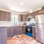 open kitchen with granite counters, stainless steel appliances, and dark wood cabinets