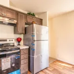 open kitchen with granite counters, stainless steel appliances, and dark wood cabinets