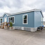 short stairway leading up to the front door of a manufactured home with lattice skirting around the foundation