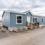 short stairway leading up to the front door of a manufactured home with lattice skirting around the foundation