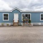 short stairway leading up to the front door of a manufactured home with lattice skirting around the foundation