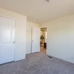 empty bedroom with plush grey carpet, a window, a detached closet, and recessed lighting