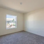 empty bedroom with plush grey carpet, a window, and recessed lighting